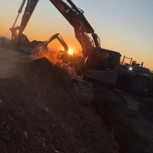 Zwei Bagger mit rotem ER im Gegenlicht