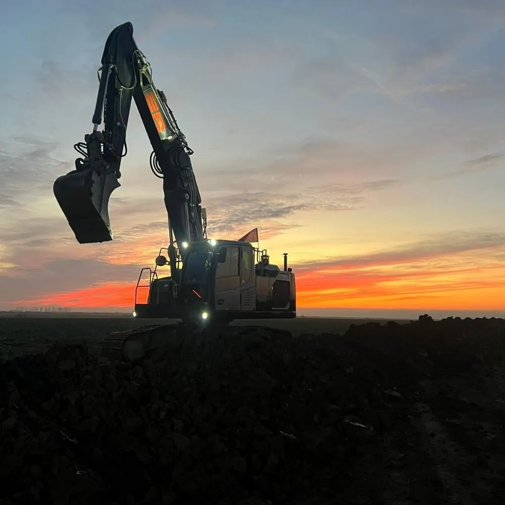 Schwarzer Bagger vor Abendhimmel