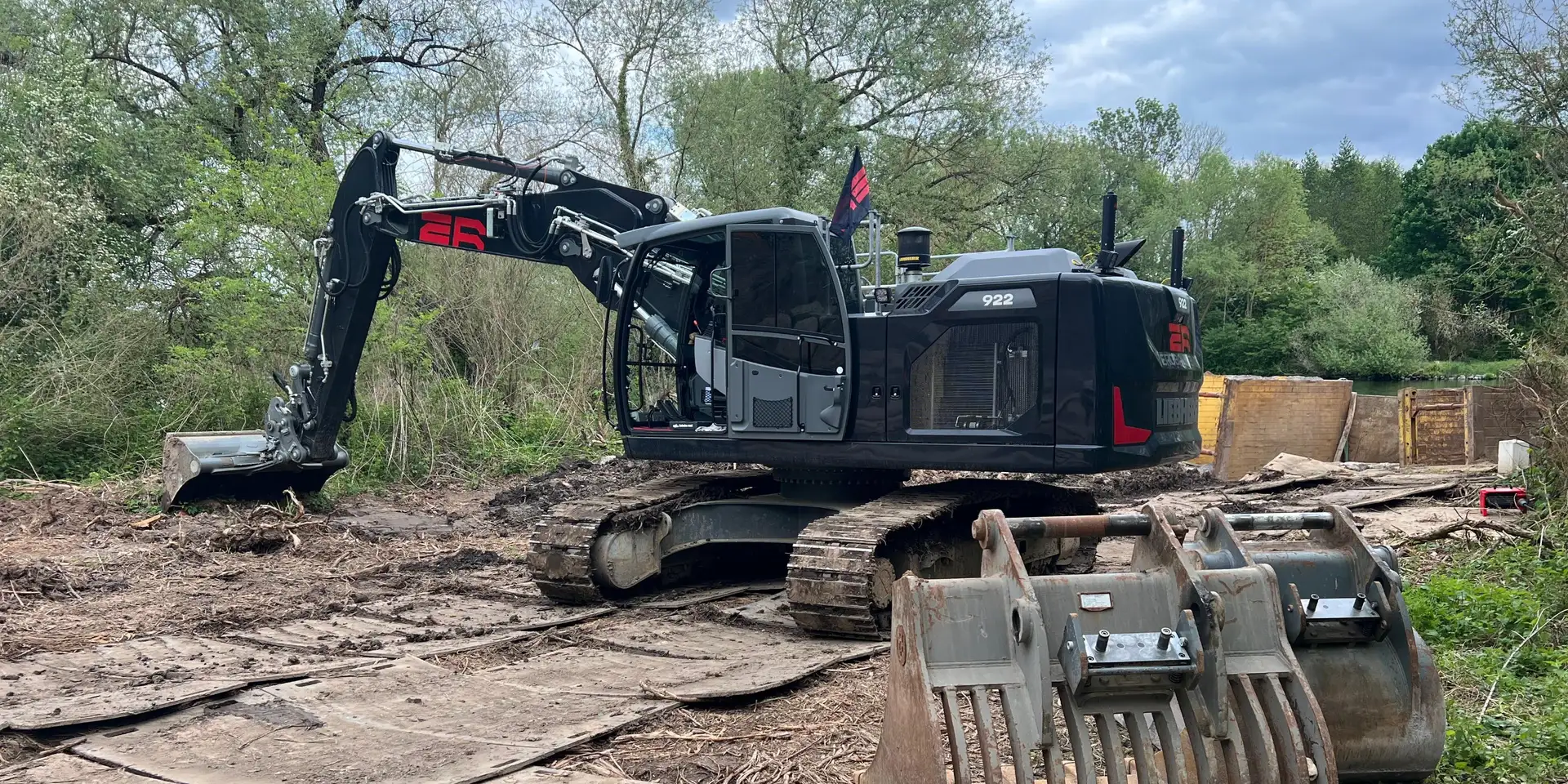 Schwarzer Liebherr-Bagger mit rotem ER auf Baggermatten