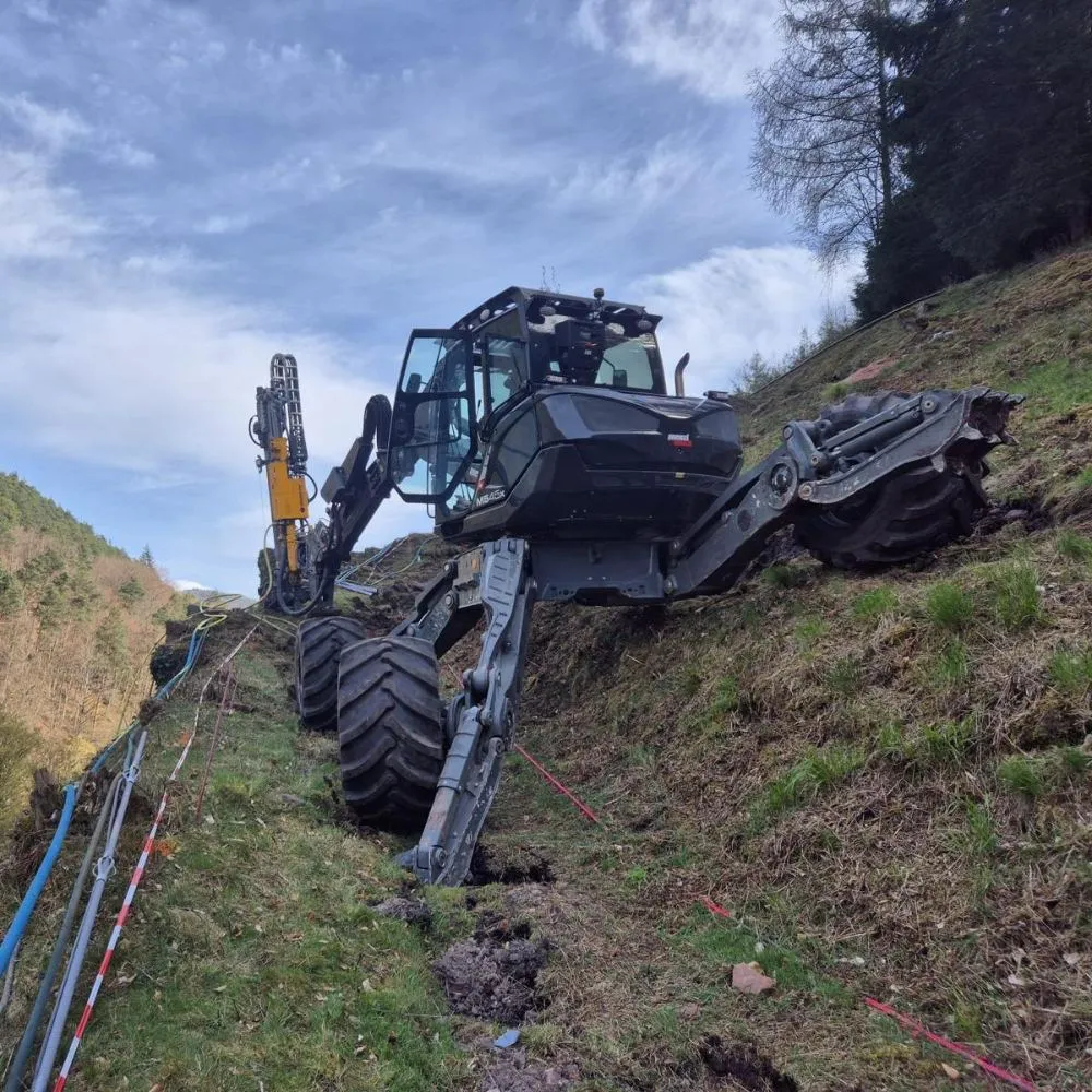 Schwarzer Spinnenbagger am Steilhang